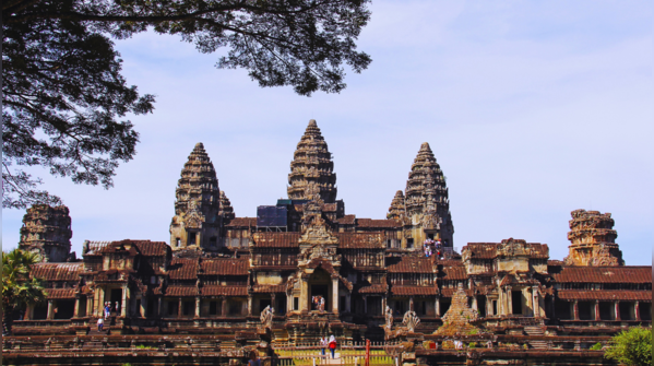 Angkor Wat reflecting in the surrounding waters at sunrise.