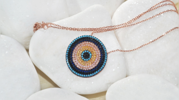 Two people discussing the Evil Eye symbol, representing the differing beliefs.