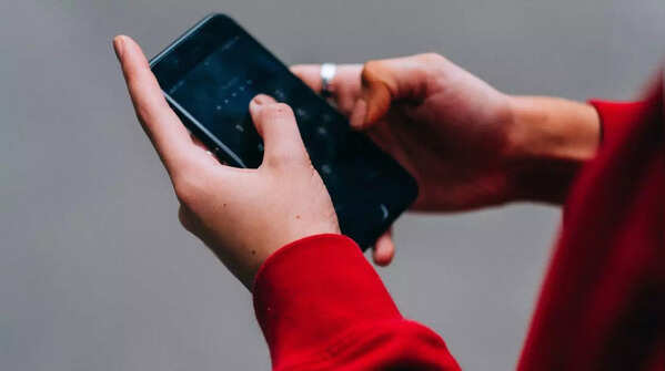 Person using both hands and both thumbs to hold the phone